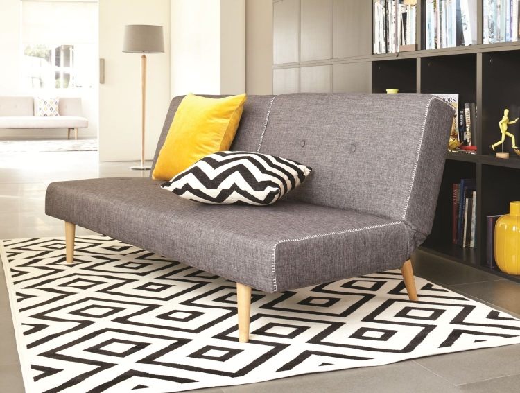 vankúše v jasných farbách ladia so sivou Rozkladacia pohovka v sivej-lôžkovej funkcii-skladacia funkcia-nohy-drevený koberec-biely-čierny vzor