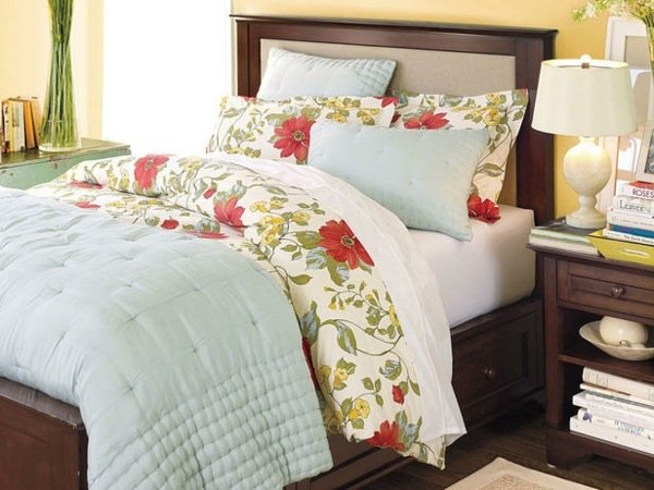 Navrhuje drevený rám postele s kvetinovým vzorom v modrej farbe