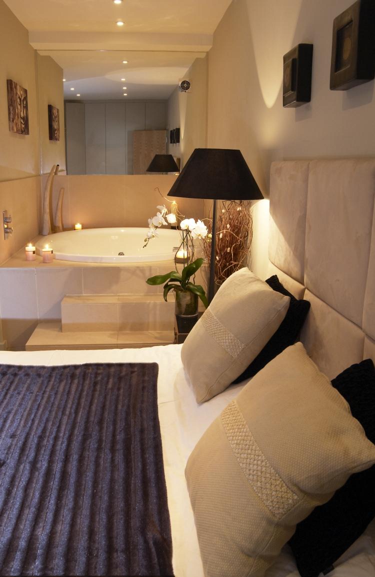 Diskrétne osvetlite spálňu a priestor na kúpanie spálňa-vírivá vaňa-vankúš-hnedá-velúrová-sviečky-romantika-vaňa-čelo postele-čalúnené