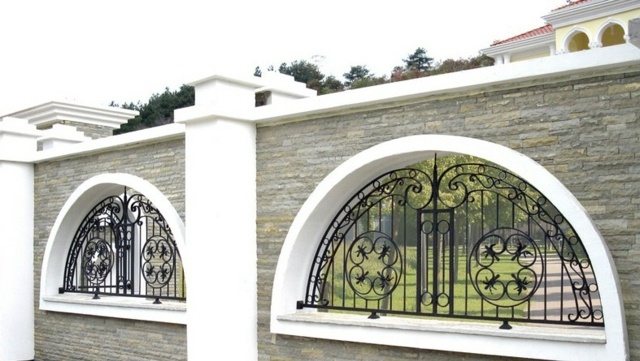 Záhradná stena z prírodného kameňa a malých kovaných prvkov Záhradný prírodný kamenný múr kované prvky biela čierna