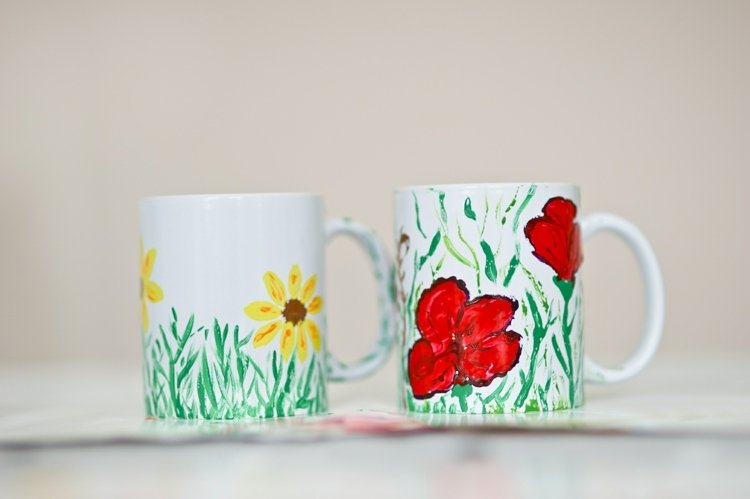 Deti maľujú poháre so žltými a červenými kvetmi a trávou