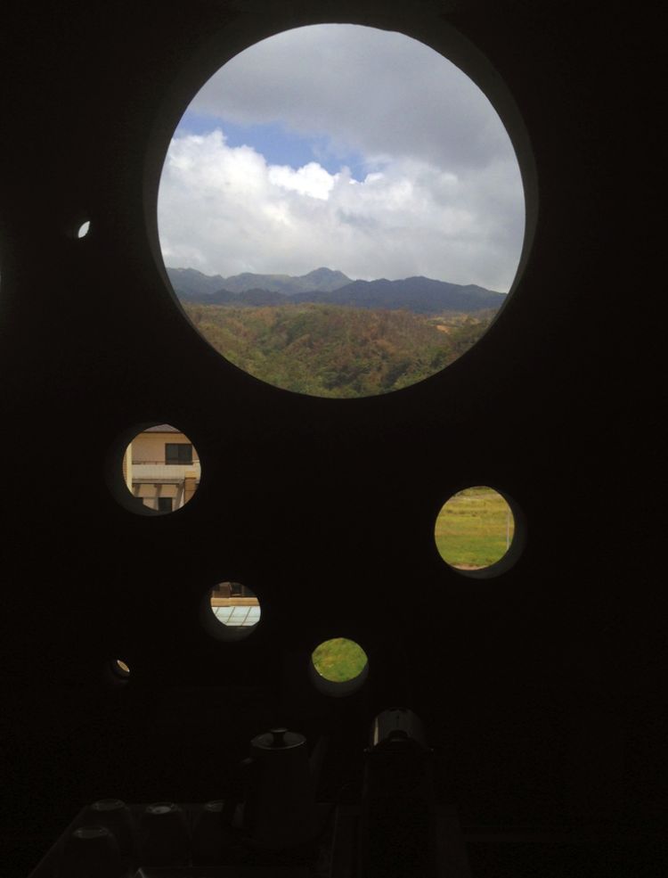 čierna fasáda moderný dizajn onyx osvetlený dom taiwan minimalistické okrúhle diery dizajnové kruhy inšpirované sprejovou architektúrou pohľad na hory