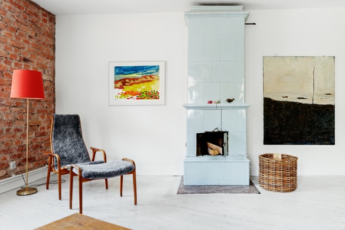 biela jednoduchá obývačka s krbom a kreslami Krb s lesklým povrchom kreslo s podperou pre nohy