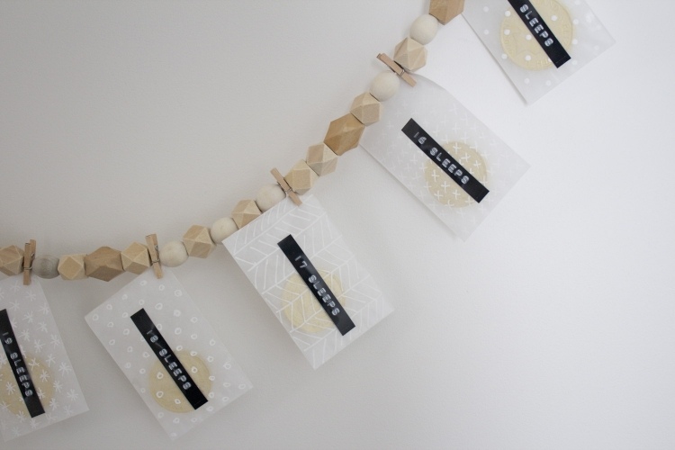 Adventné kalendáre ako malé obálky na girlande z drevených korálikov Škandinávske vianočné dekorácie-urob si sám-nápady na drevo-veniec-advent-kalendár-mini-štipce na bielizeň