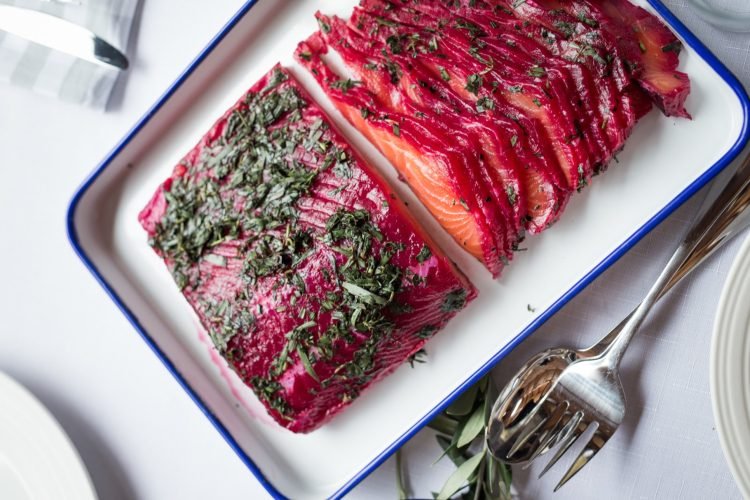 Údeného lososa pripravuje niekoľko ľudí