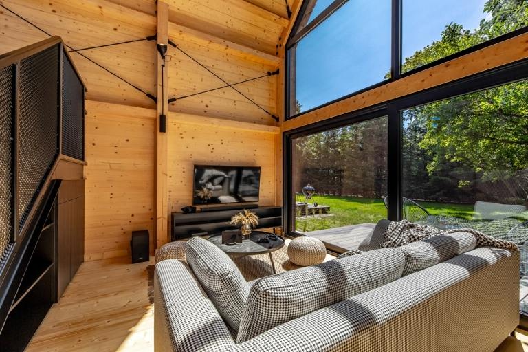 Drevené steny obývačky pokrývajú veľké predné okná