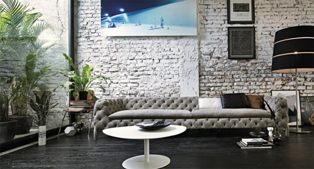 Pohovka tehlová stena neošetrený konferenčný stolík okolo paliem