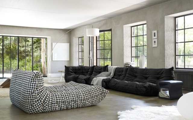 Obývacia izba denná posteľ kožená sedačka bočný stôl betónová podlaha