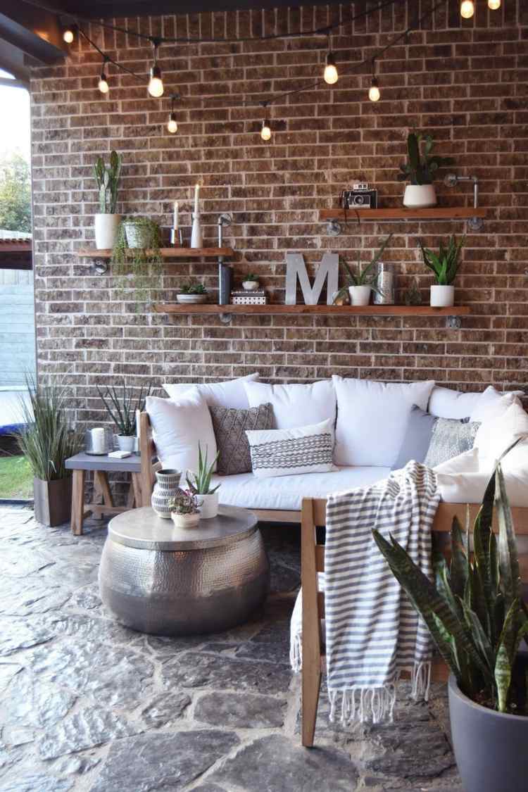 Police na tehlovej stene na terase a rozprávkové svetlá