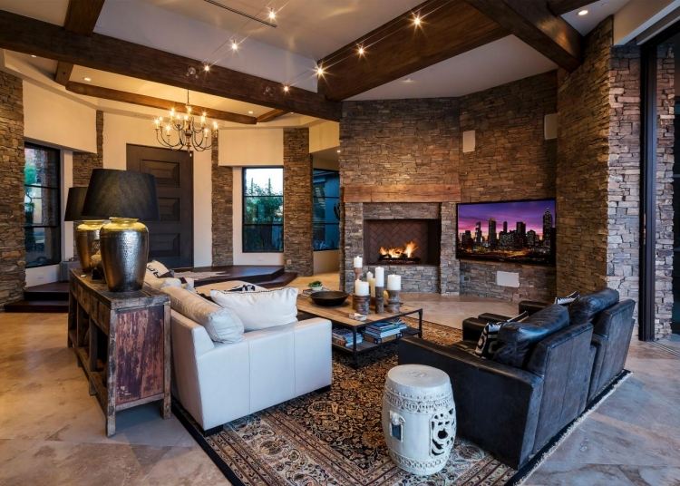 moderná obývačka v štýle vidieckeho domu s pohodlnými koženými pohovkami kamenná stena-obývačka-sedenie-koža-čalúnenie-dekorácia-prírodný kameň-drevené trámy