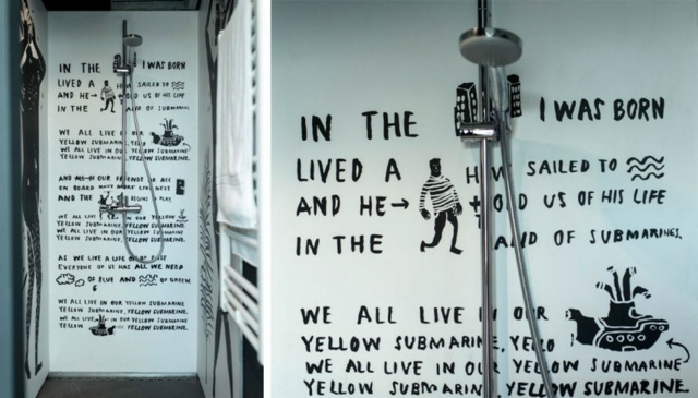 Sprcha s umeleckou stenou a nápisom v čiernych hausbótoch Rummelsburger-Bucht