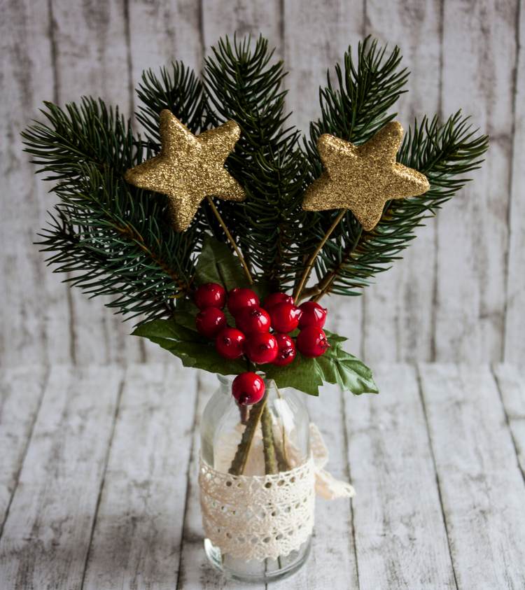 Jedľové konáre vo váze sa lesknú jednorazovými sklenenými hviezdičkami