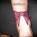 tatuaż z różową kokardką w kropki na nogawce