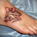 tatuaże serduszka, kokardki i łyżwy na nodze