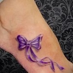 elegancki tatuaż z kokardką na nodze