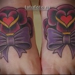 oldschoolowy tatuaż z różami i kokardkami na nogach