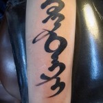 وشم بأحرف هيروغليفية كبيرة مدورة على الذراع