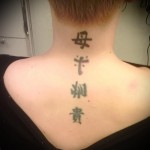 وشم بأربعة حروف هيروغليفية من العنق إلى مؤخرة الفتاة