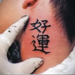 وشم الهيروغليفية على الرقبة بالقرب من أذن الرجل