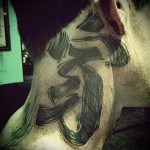 هيروغليفية كبيرة في وشم على كامل الرقبة