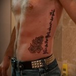 татуировка йероглифи на ребрата на човек - вертикален надпис