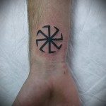 Fotó kolovrat tetoválásról - fekete egyszerű rajz a férfi csuklóján