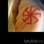 Fotó egy piros Kolovrat tetoválásról a bordákon (egy férfi oldalán)