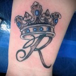 tatuaż z koroną na nadgarstku z pierwszą literą imienia