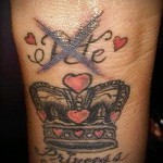 Korona tatuaż na ramieniu z inicjałami i sercami