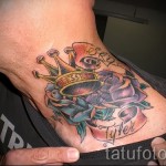 Korona tatuaż na szyi z kwiatami i napisami