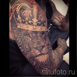 tatuaż lwa z koroną - świetna i fajna praca z rękawem na całym ramieniu dla mężczyzny