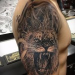 tatuaż lwa z koroną - wariant z uśmiechem na całym ramieniu