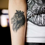 Tatuaż z koroną lwa na ramieniu dziewczyny