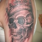 czaszka z tatuażem korony na ramieniu