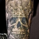 czaszka z tatuażem w koronie - realistyczna wersja na zgięciu ramienia