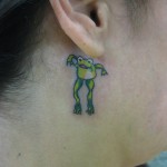 Béka tetoválás a lány füle mögött