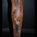 nagy tetoválás a lábán egy késsel mintával a tűzön