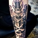 gyönyörű tetoválás a karon egy nagy késsel