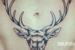 Szarvas tetoválás szarvakkal az alsó hason