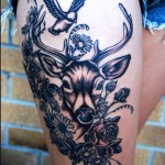 Szarvas tetoválás virágokban és madárral