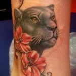 párduc tetoválás és két virág a láb alján