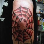pókháló tetoválás a könyökön - piros virágokkal készült - egy csillag látható a képen