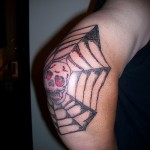 Pókháló tetoválás a könyökön - dühös koponyarajz