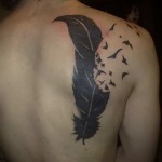 férfiak tetoválnak egy tollal a lapockán