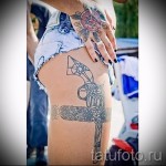 Fotó egy harisnyakötő tetoválásról és egy nagy revolverről