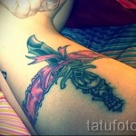 Fotó egy harisnyakötő tetoválásról és egy tőrről, faragott markolattal