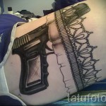 Fotó tetováló harisnyakötőről és fekete pisztolyról