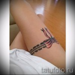 Fotó egy harisnyakötő tetoválásról egy karcsú női lábon