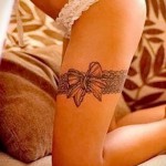 Fénykép harisnyakötő tetoválásról, nagy íjjal, fehér fehérneműben