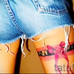 Fotó a harisnyakötő tetoválásról, piros masnival a szamár alatt